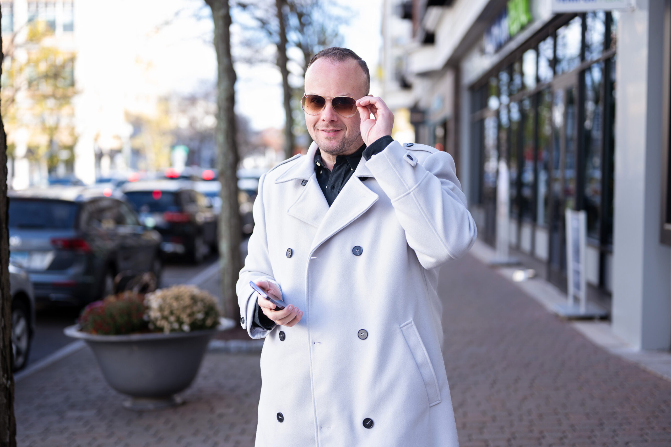 Dr. Mike stands in a a busy urban area wearing a white coat and sunglasses