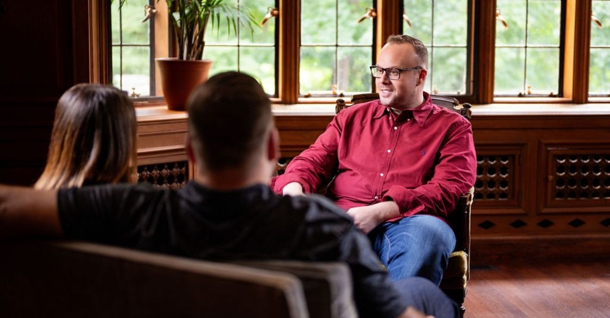 Dr. Mike talks through relationship issues to a couple in his therapy session.