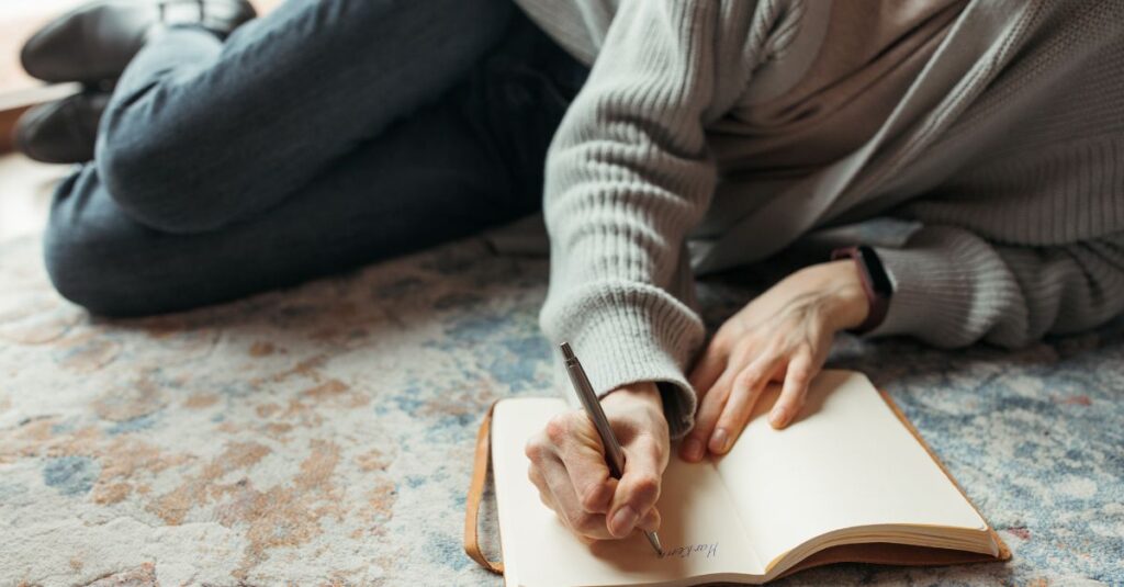 Man lays on a luxurious rug journaling.