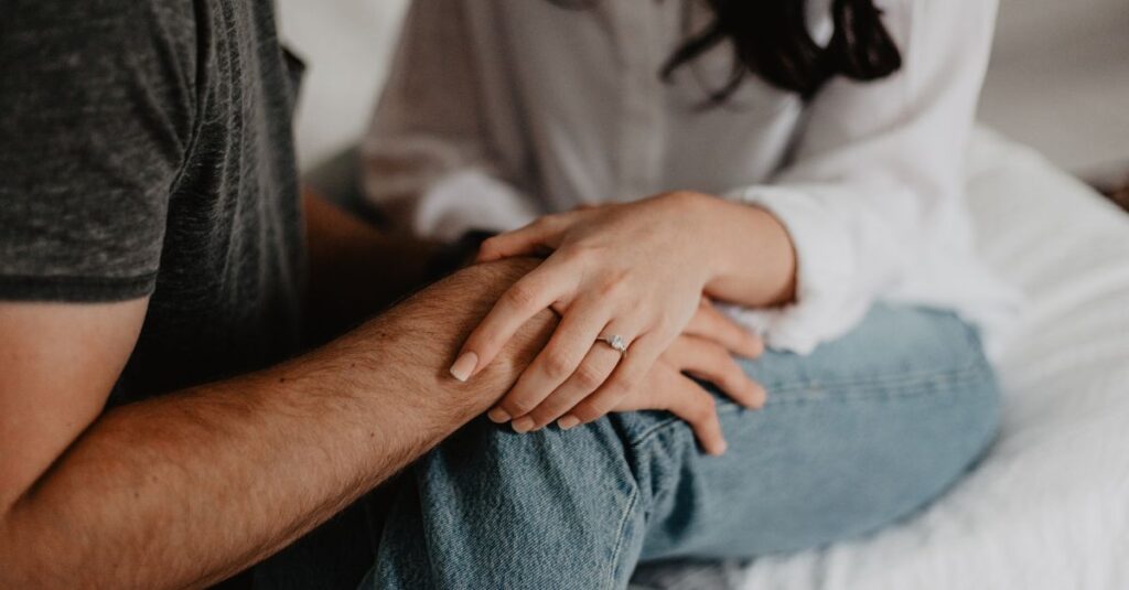 Close-up of a couple holding hands, symbolizing trust, emotional safety, and healthy attachment.