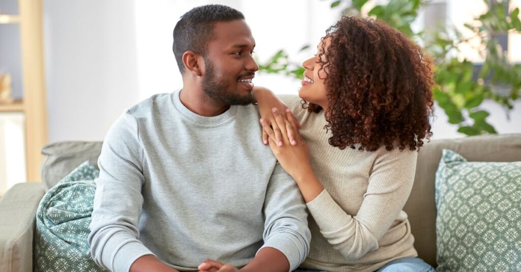 Couple sitting close together and talking with empathy, representing emotional support and understanding in relationships affected by depression.