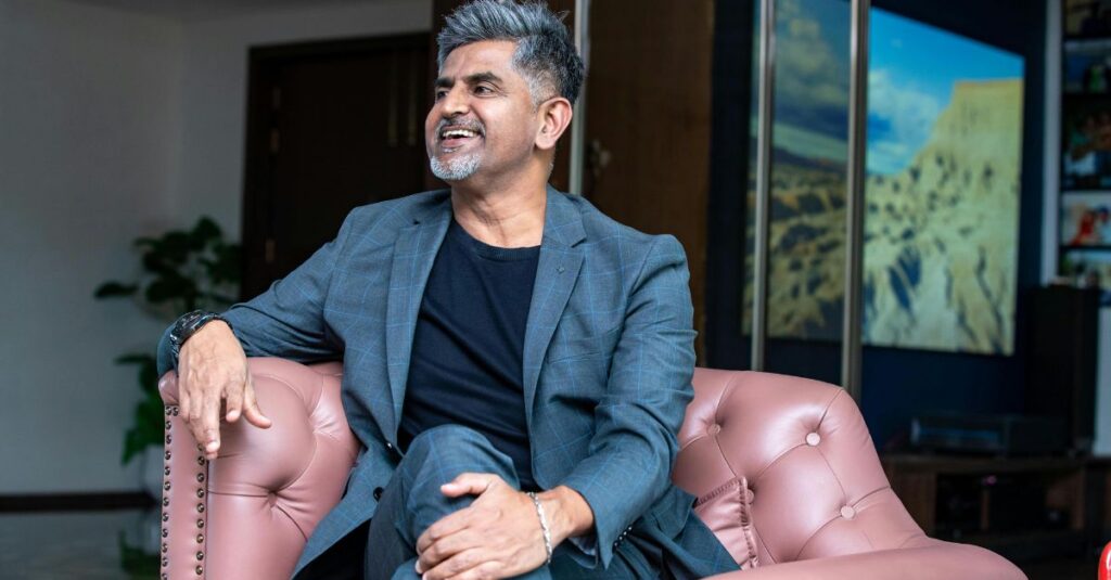 Mature man smiling while sitting comfortably in a chair, symbolizing confidence, authenticity, and emotional fulfillment.