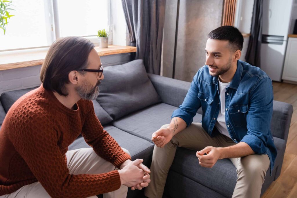 Mature man having an open, supportive conversation with a loved one, representing connection and understanding during the coming-out process.