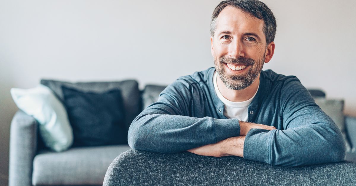 A confident middle-aged man sitting comfortably, representing sexual confidence and well-being at any age.