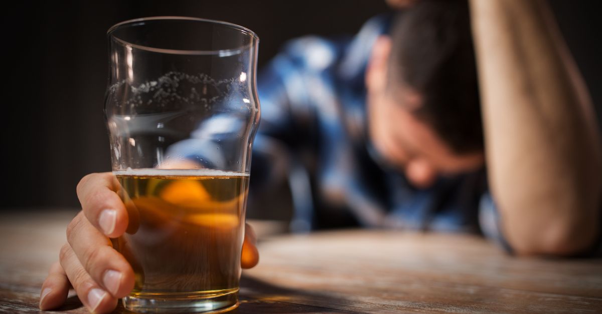 Man drinking alone dealing with stress before alcohol fueled anger episode