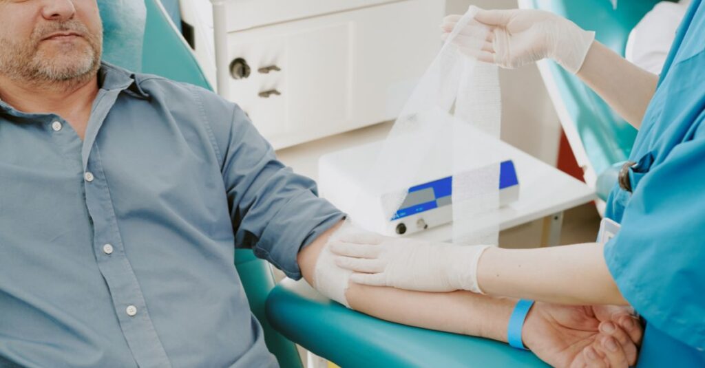 Middle-aged man getting blood drawn by a nurse.