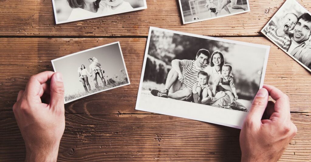 Man holding old family photos.