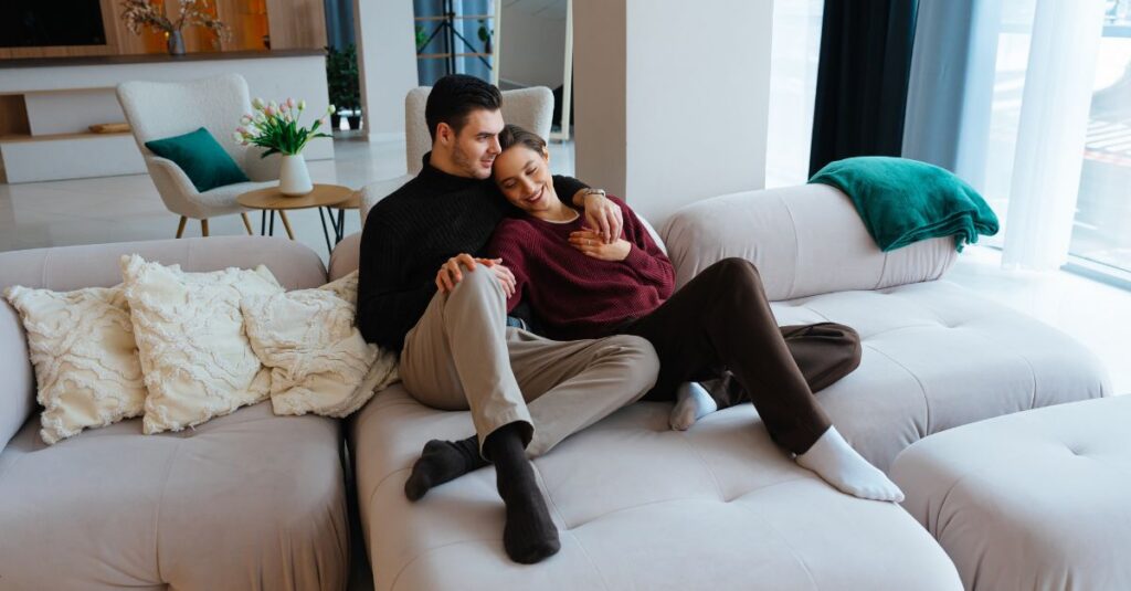 Couple cuddling and laughing on the couch together