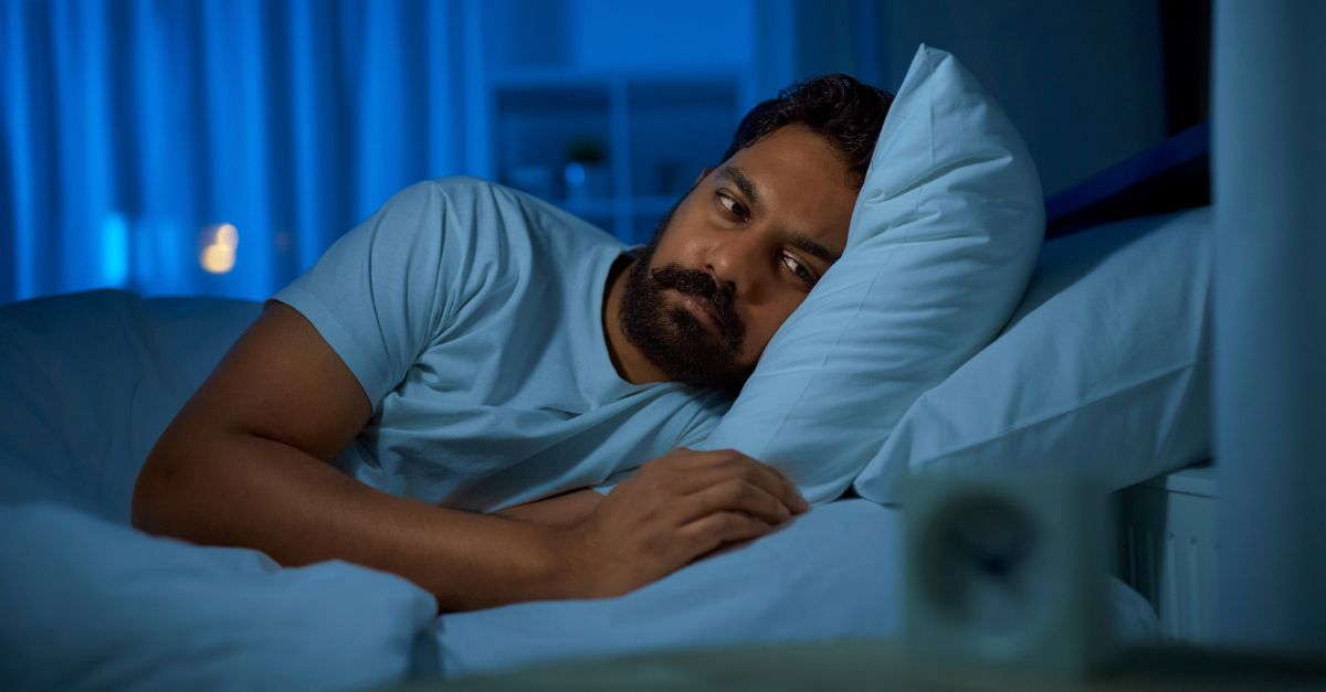 Man lays in bed late at night