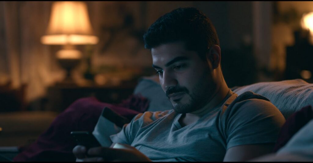 Man scrolling on his phone in his living room